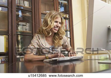 Young woman using computer in living room View Large Photo Image Stock Photography - Young woman using computer in living room. Fotosearch
