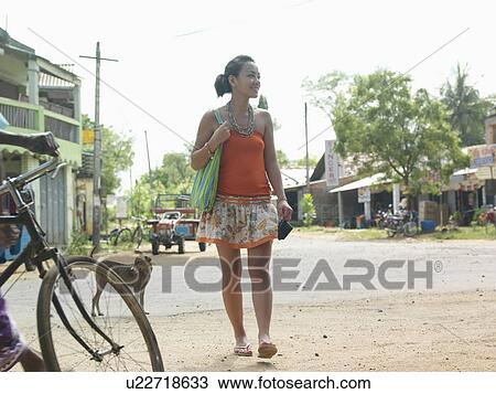 Young woman walking dirt road smiling View Large Photo Image Stock Image - Young woman walking dirt road smiling. Fotosearch