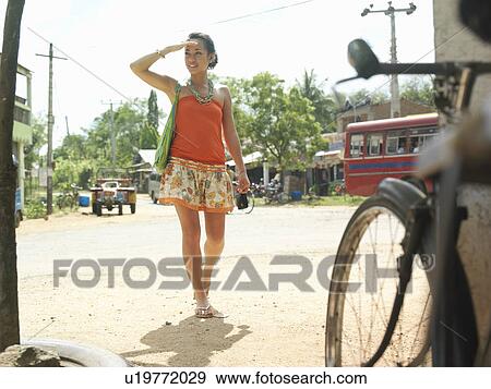 Young woman walking dirt road smiling View Large Photo Image Stock Photo - Young woman walking dirt road smiling. Fotosearch