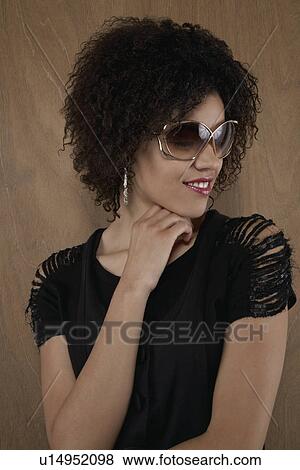 Young woman wearing sunglasses View Large Photo Image Stock Photo - Young woman wearing sunglasses. Fotosearch