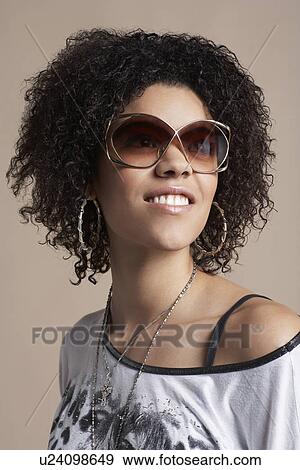 Stock Photo - Young woman wearing sunglasses. Fotosearch