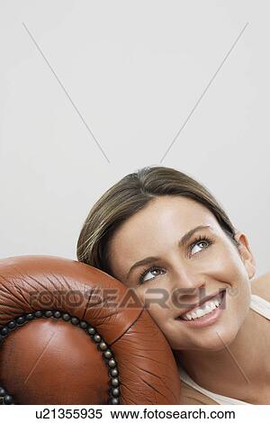 Young woman with head leaning against sofa View Large Photo Image Stock Photography - Young woman with head leaning against sofa. Fotosearch