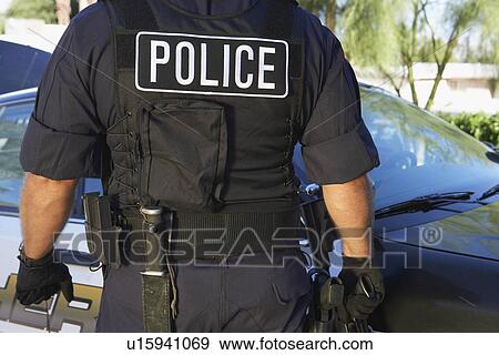ضابط شرطة إلى داخل الصدرة مضاد للرصاص إلى العراء منظر الظهر ألبوم الصور U15941069 Fotosearch