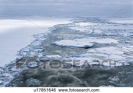 Stock Photograph - Antarctica Weddell Sea Ice floe clouds reflecting in water. Fotosearch
