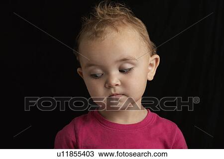 Stock Image - Baby girl (1-2) on black background close-up. Fotosearch