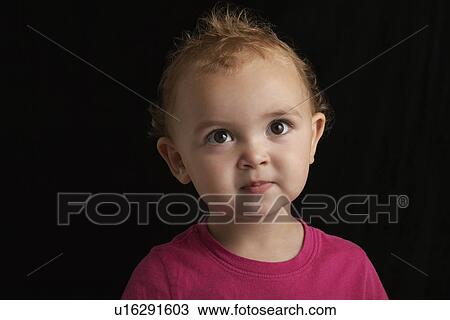 Stock Image - Baby girl (1-2) on black background close-up. Fotosearch