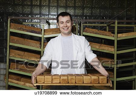 Stock Photo - Baker Carrying Loaves of Fresh Bread. Fotosearch