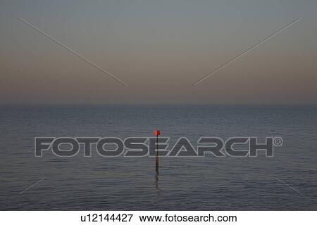 Beacon in ocean at dusk View Large Photo Image Stock Photo - Beacon in ocean at dusk. Fotosearch