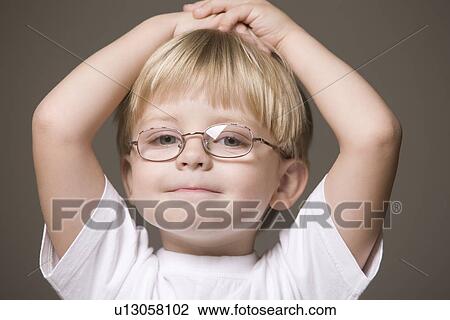 Blonde-haired boy wearing glasses with hands on head View Large Photo Image Stock Image - Blonde-haired boy wearing glasses with hands on head. Fotosearch