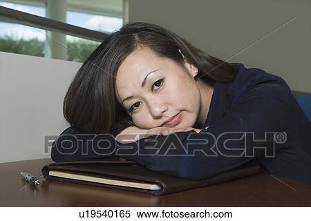 Bored Asian Businesswoman with Head on Desk View Large Photo Image Stock Photography - Bored Asian Businesswoman with Head on Desk. Fotosearch