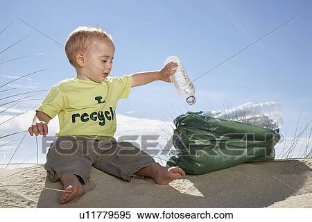 Boy (1-2) playing with plastic bottles on sand dune View Large Photo Image Stock Photography - Boy (1-2) playing with plastic bottles on sand dune. Fotosearch