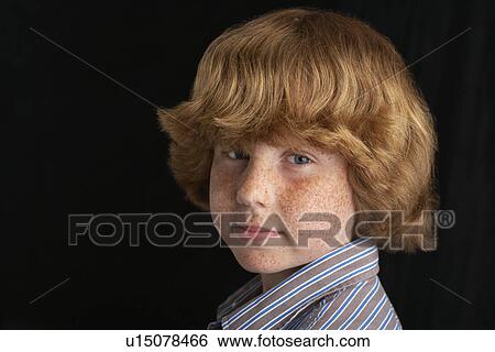 Stock Photograph - Boy (10-12) on black background portrait close-up. Fotosearch