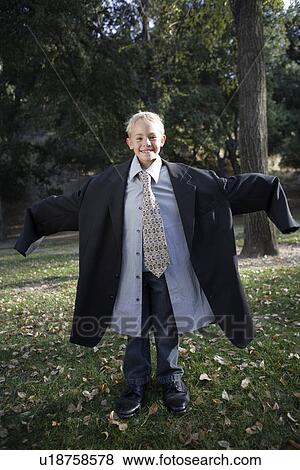 Boy (10-12) wearing oversized suit View Large Photo Image Stock Photo - Boy (10-12) wearing oversized suit. Fotosearch