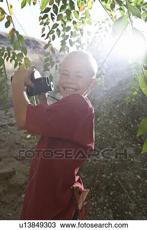 Boy (7-9) using binoculars View Large Photo Image Stock Image - Boy (7-9) using binoculars. Fotosearch