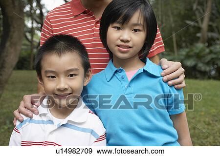 Boy and girl (7-9) with father in park View Large Photo Image Stock Photo - Boy and girl (7-9) with father in park. Fotosearch