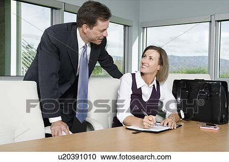 Stock Image - Business People Chatting in Meeting Room. Fotosearch