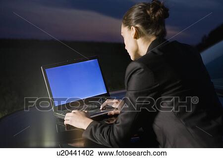 Business woman using laptop on car View Large Photo Image Stock Image - Business woman using laptop on car. Fotosearch