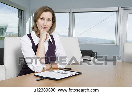 Stock Image - Businesswoman Sitting at Meeting Table Portrait. Fotosearch