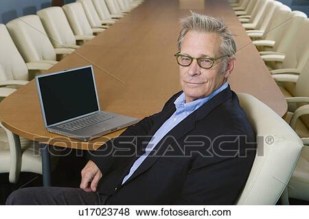 Stock Photo - Businesswoman Sitting at Meeting Table Portrait. Fotosearch