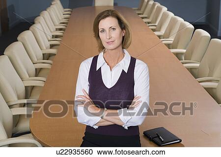 Stock Image - Businesswoman Standing in Meeting Room High Angle. Fotosearch