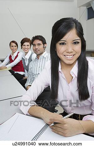 Stock Image - Cheerful Multi Racial Group of Business people Sitting at Desk. Fotosearch