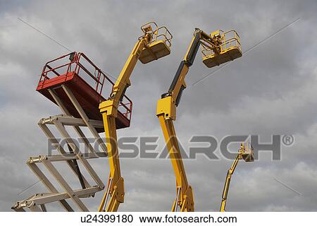 Stock Image - Cherry pickers against stormy sky. Fotosearch