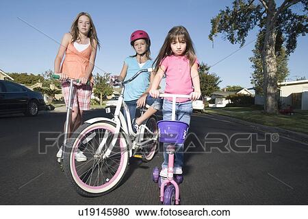 Stock Image - Children with scooters and bicycle. Fotosearch
