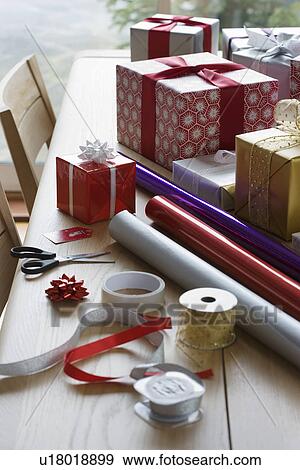 Stock Photo - Christmas gifts wrapping paper and accessories on table. Fotosearch