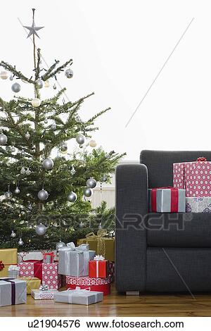 Stock Photograph - Christmas presents by tree and on armchair. Fotosearch