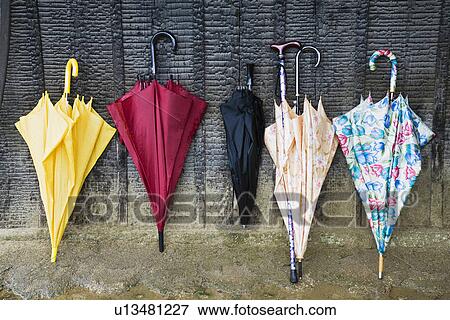 Colorful Umbrellas Leaning Against a Wall View Large Photo Image Stock Photo - Colorful Umbrellas Leaning Against a Wall. Fotosearch