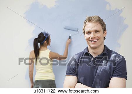 Couple painting wall man in foreground View Large Photo Image Stock Image - Couple painting wall man in foreground. Fotosearch