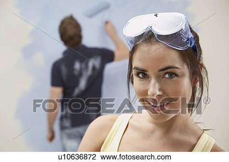 Couple painting wall woman in foreground View Large Photo Image Stock Image - Couple painting wall woman in foreground. Fotosearch