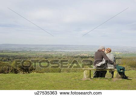 Stock Image - Couple Sitting on a Park Bench. Fotosearch
