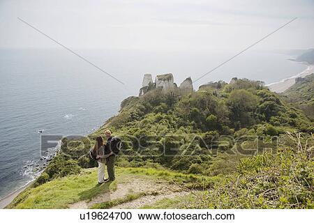 Stock Image - Couple Standing on an Outlook Above the Water. Fotosearch