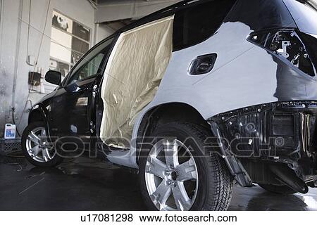 Stock Photo - Damaged sports utility vehicle in garage. Fotosearch