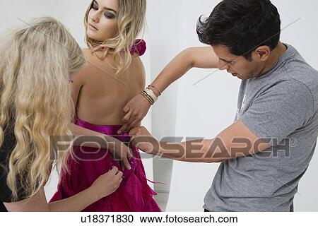 Stock Image - Designers Adjusting Dress on Model. Fotosearch