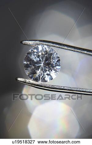 Diamond held by tweezers close-up View Large Photo Image Stock Photo - Diamond held by tweezers close-up. Fotosearch