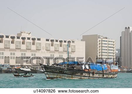 Dubai UAE A dhow an old wooden sailing vessel filled with cargo leaves the dock in Deira. View Large Photo Image Stock Photograph - Dubai UAE A dhow an old wooden sailing vessel filled with cargo leaves the dock in Deira.. Fotosearch