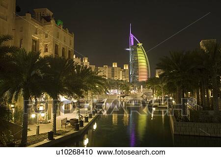 Stock Image - Dubai UAE colourfully lit world famous Burj Al Arab hotel Dubai icon. Fotosearch