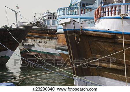 Dubai UAE Dhows old wooden sailing vessels are docked along the Deira side of Dubai Creek. View Large Photo Image Stock Image - Dubai UAE Dhows old wooden sailing vessels are docked along the Deira side of Dubai Creek.. Fotosearch