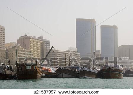 Dubai UAE Dhows old wooden sailing vessels are docked along the Deira side of Dubai Creek. View Large Photo Image Stock Photo - Dubai UAE Dhows old wooden sailing vessels are docked along the Deira side of Dubai Creek.. Fotosearch