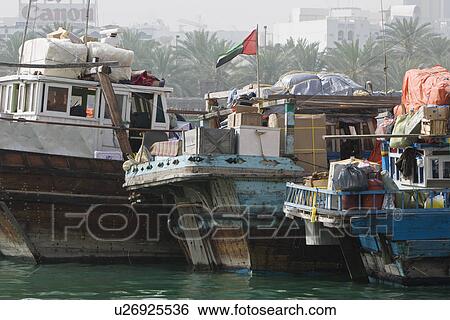 Dubai UAE Dhows old wooden sailing vessels are docked along the Deira side of Dubai Creek. View Large Photo Image Stock Photograph - Dubai UAE Dhows old wooden sailing vessels are docked along the Deira side of Dubai Creek.. Fotosearch