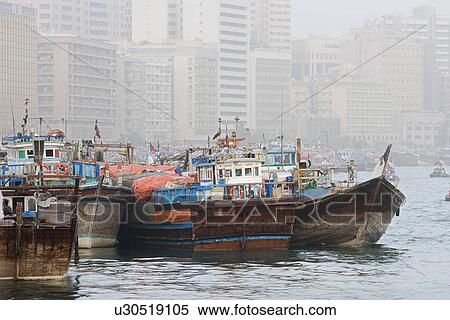 Stock Photography - Dubai UAE Dhows old wooden sailing vessels are docked along the Deira side of Dubai Creek.. Fotosearch
