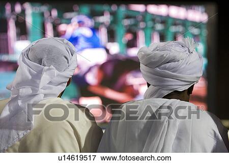 Stock Photo - Dubai UAE Two men traditionally dressed in dishdashs and gutras. Fotosearch