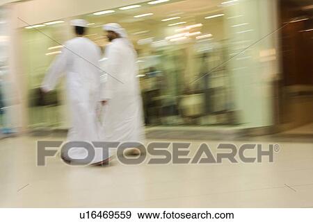 Stock Photo - Dubai UAE Two men traditionally dressed in dishdashs and gutras white robes and headdresses.. Fotosearch
