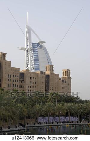 Stock Photograph - Dubai UAE world famous Burj Al Arab Hotel seen beyond old windtowers. Fotosearch