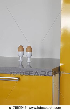 Eggs in eggcups on kitchen counter View Large Photo Image Stock Photography - Eggs in eggcups on kitchen counter. Fotosearch