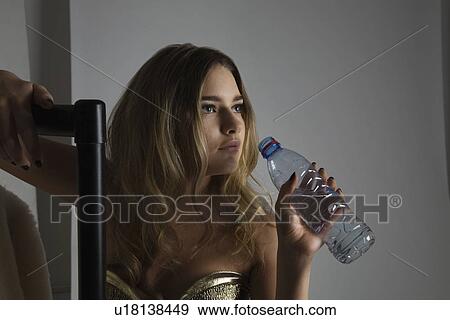 Stock Photo - Fashion Model Drinking Water During Photo Shoot. Fotosearch