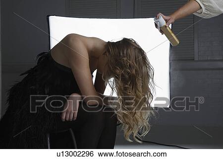 Stock Photograph - Fashion Model Having Hair Sprayed at Photo Shoot. Fotosearch