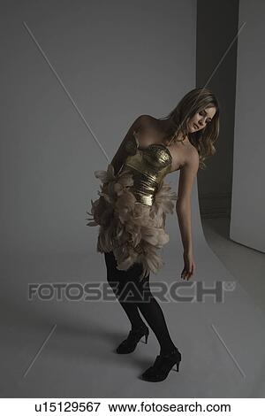 Fashion Model Modeling Gold Dress With Feathers View Large Photo Image Stock Photo - Fashion Model Modeling Gold Dress With Feathers. Fotosearch